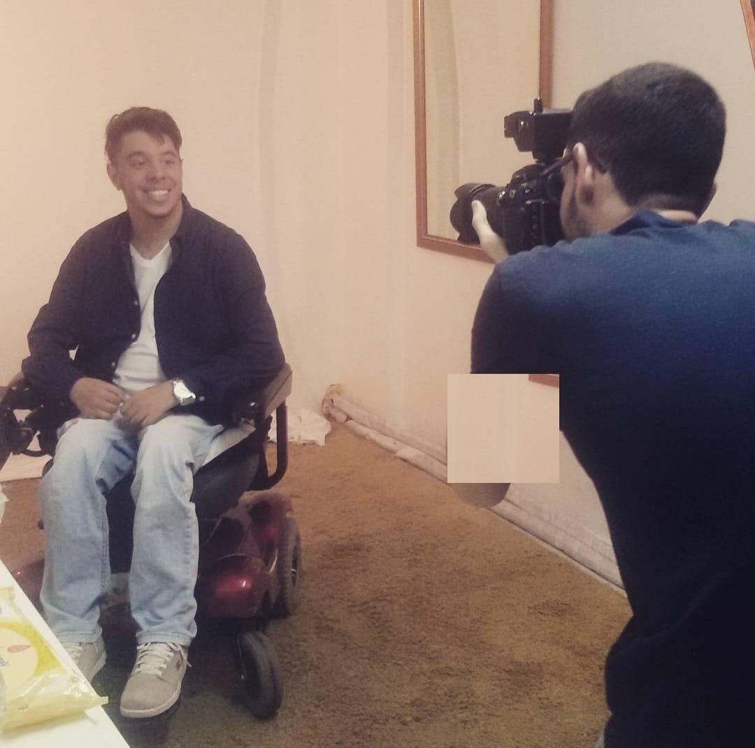 Berguim sorrindo durante a gravação de uma entrevista, sentado em sua cadeira de rodas motorizada.